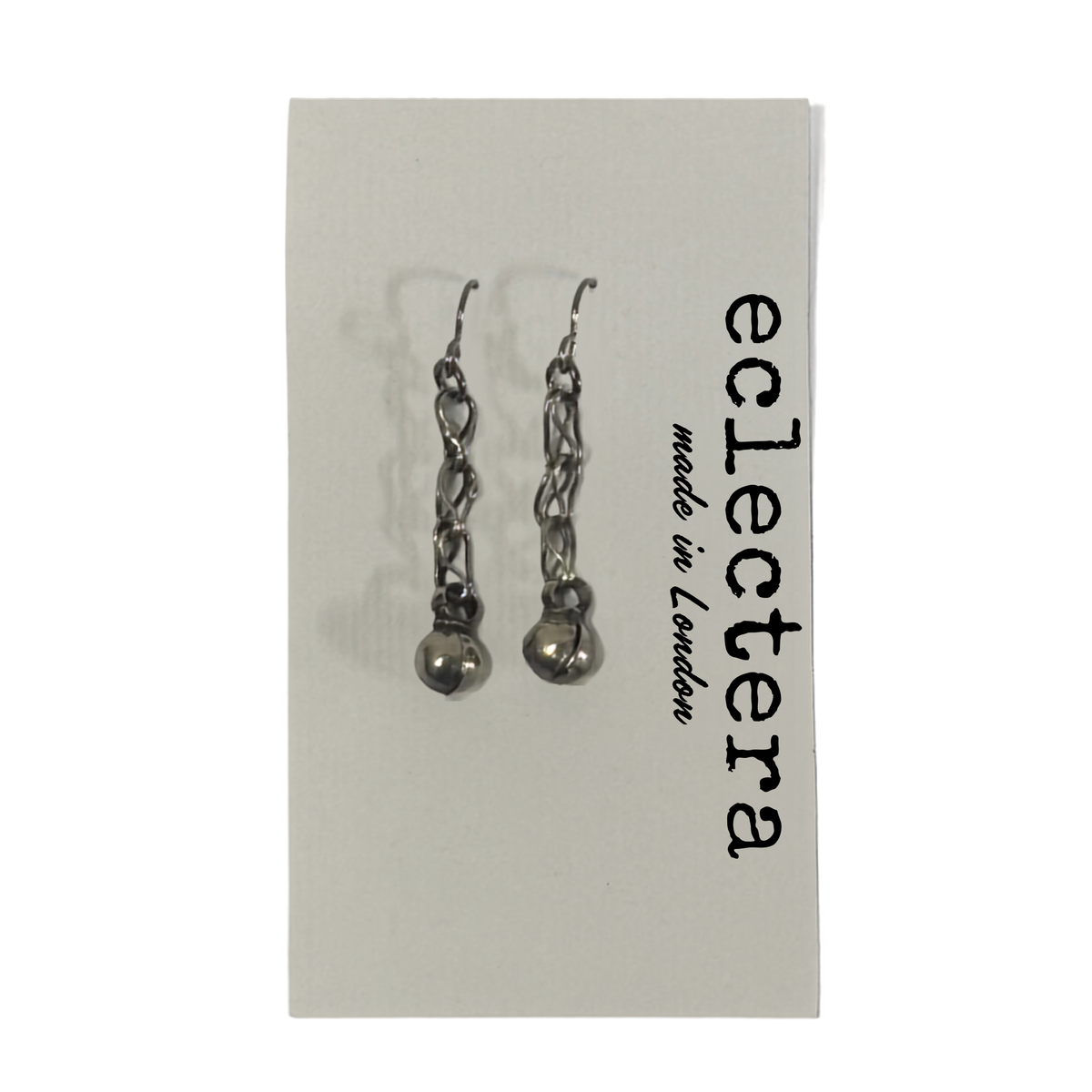A pair of silver-toned dangle earrings with chain links and small spherical charms, displayed on a white card printed with the brand name 'eclectera made in London'.