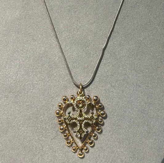 Necklace with a gold heart-shaped pendant on a gray background