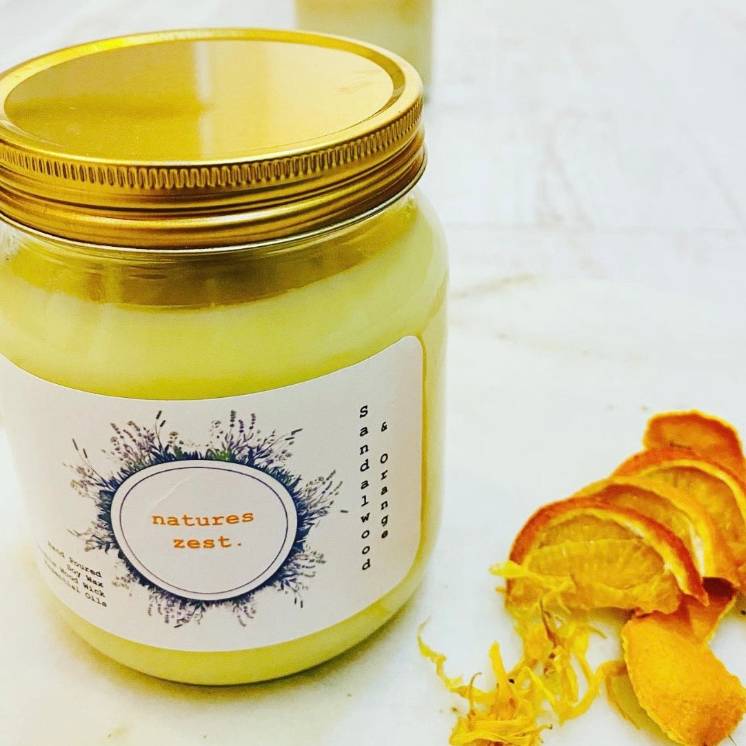 Jar of 'Natures Zest' candle with a gold lid on a white background