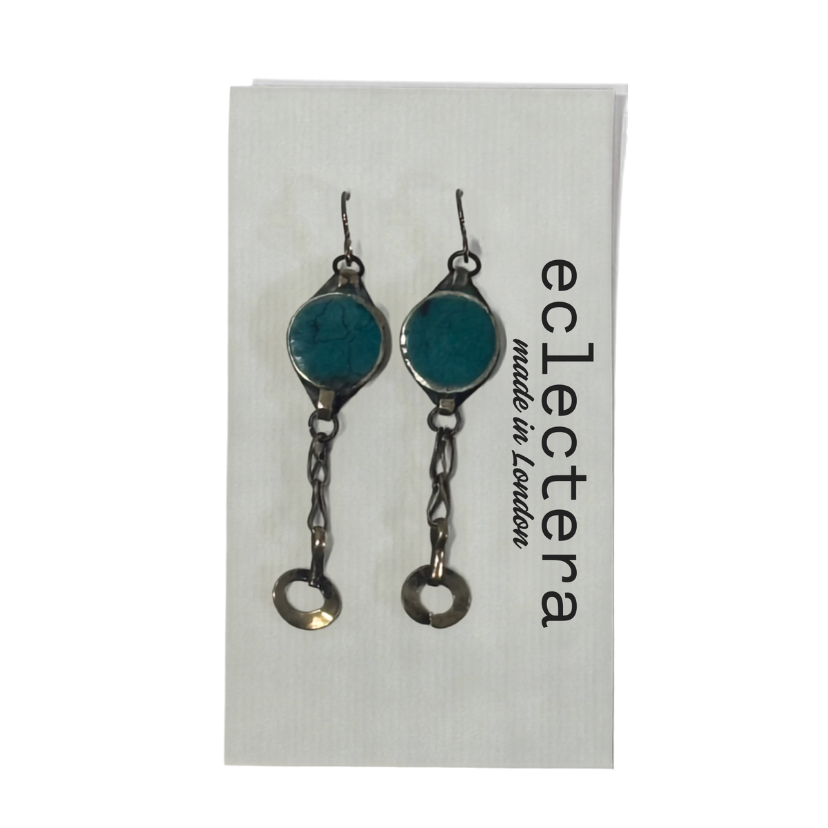 A pair of handmade dangle earrings with round turquoise-blue stones in silver-toned settings, hanging from silver-toned chains with circular drop charms. They are displayed on a white backing card printed with the brand name 'eclectera made in London'.