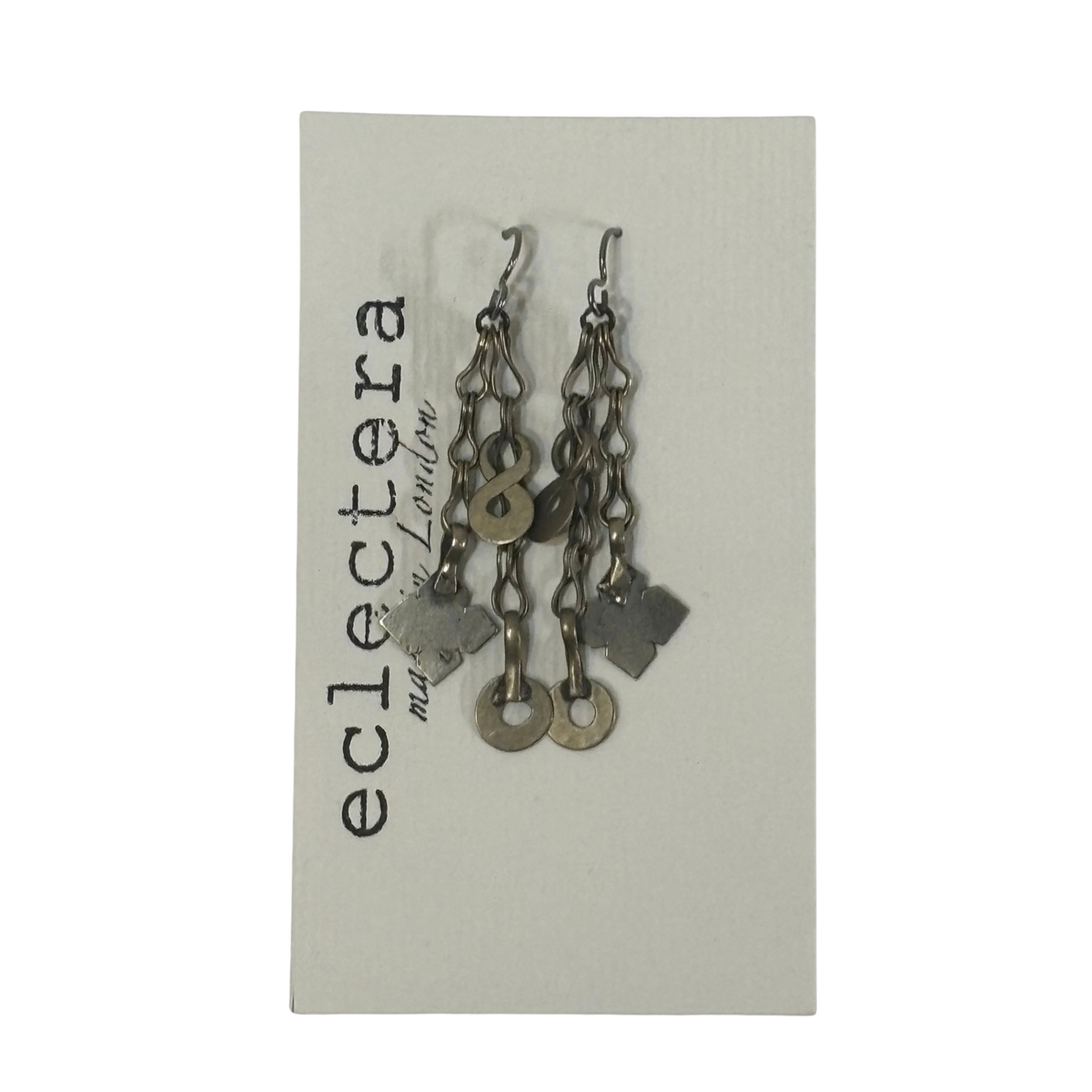 A pair of handmade dangle earrings made of silver-toned chains, key rings, and clover charms, displayed on a light gray card printed with the brand name 'eclectera'.