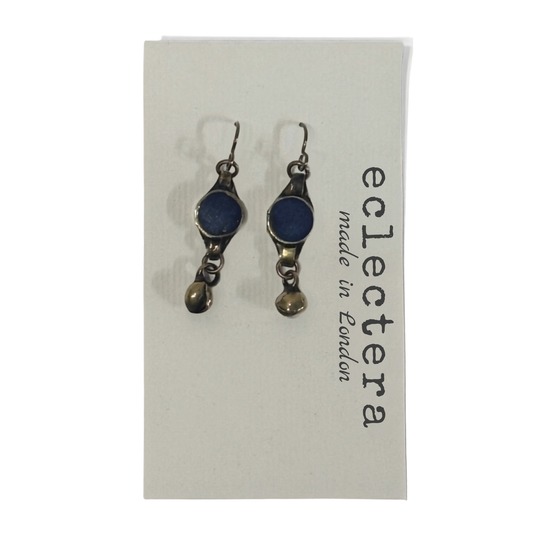 A pair of Eclectera dangle earrings with dark blue oval stones and antiqued bronze-toned metal, displayed on a white brand card that reads 'eclectera made in London'.