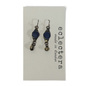 A pair of Eclectera dangle earrings with dark blue oval stones and antiqued bronze-toned metal, displayed on a white brand card that reads 'eclectera made in London'.