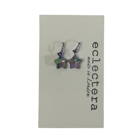 A pair of iridescent star-shaped dangle earrings on a light gray display card printed with the brand name 'eclectera made in London'.