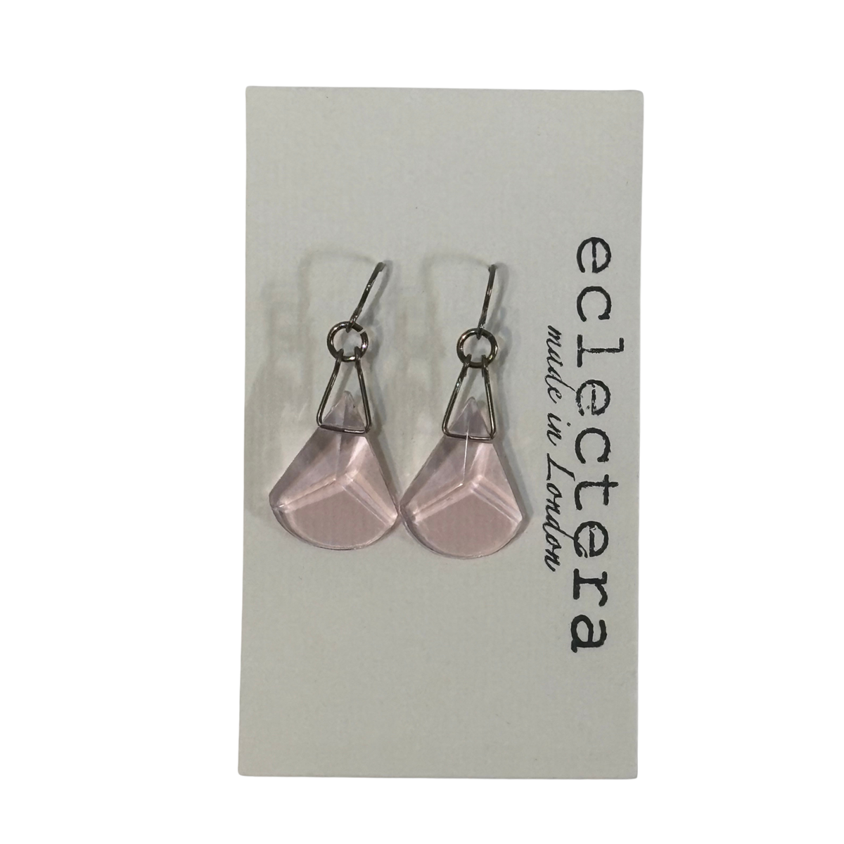 A pair of silver-tone dangle earrings with faceted light pink teardrop-shaped drops, displayed on a white card labeled 'eclectera made in London'.
