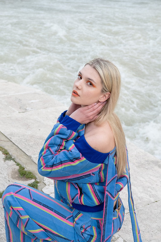 KARDASCIAN (off-shoulder kilted bomber jacket in kente)