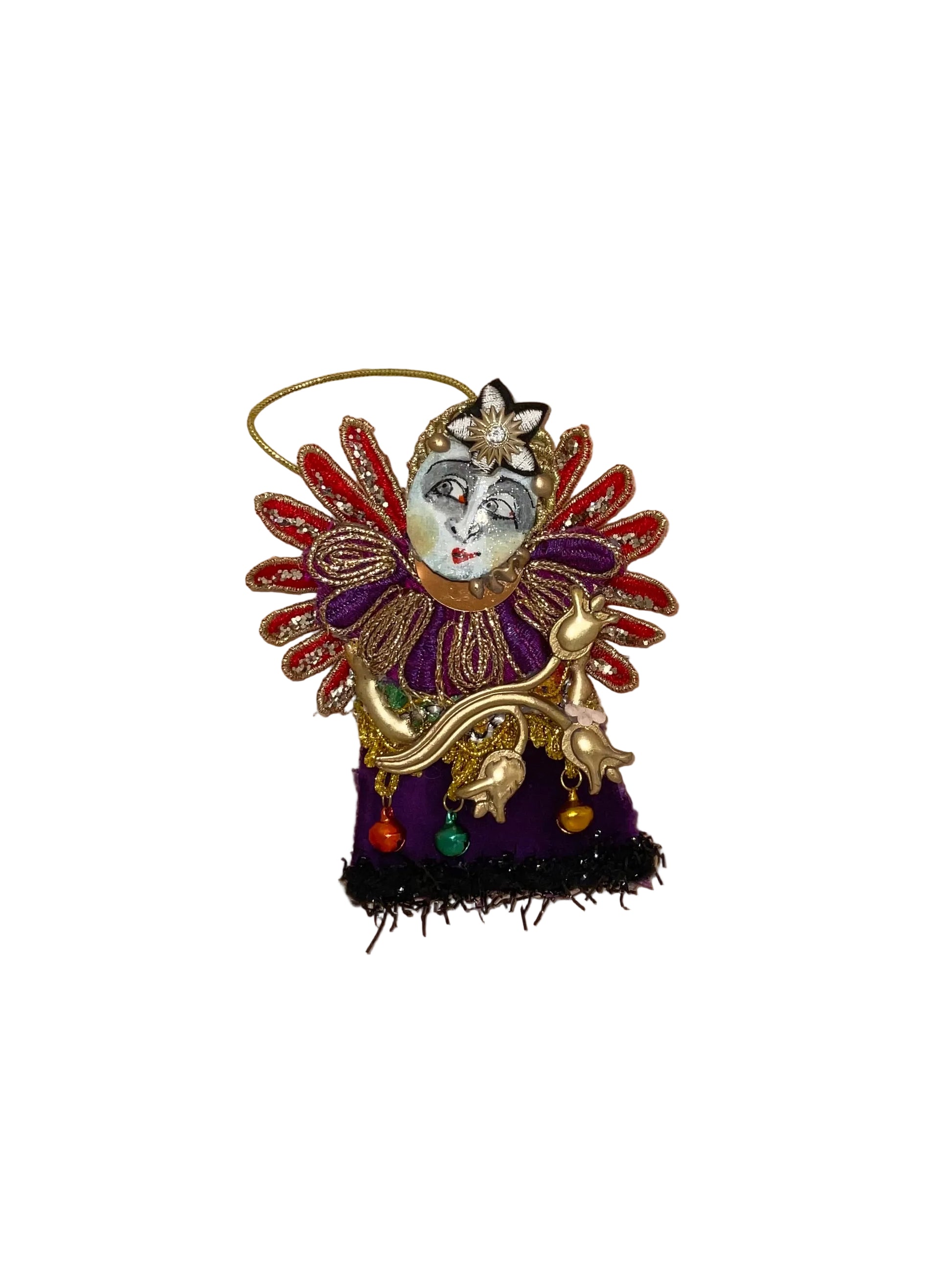 Decorative ornament with face and colorful details on a wooden surface