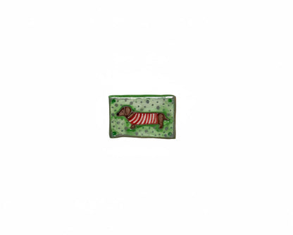 Small rectangular ceramic tile with a dog design on a wooden surface