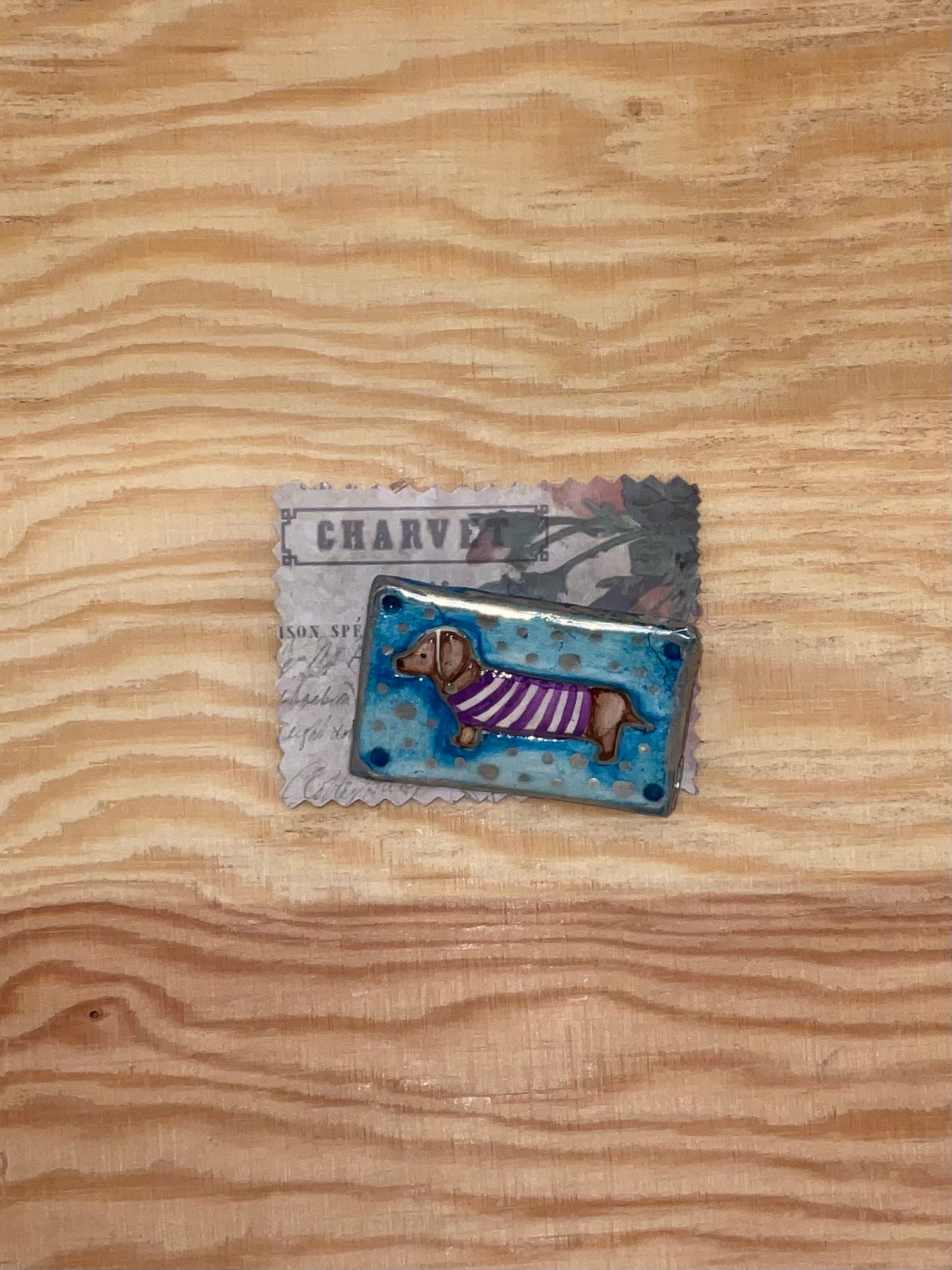 Small rectangular object with a dog design on a wooden surface