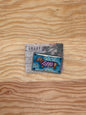 Small rectangular object with a dog design on a wooden surface