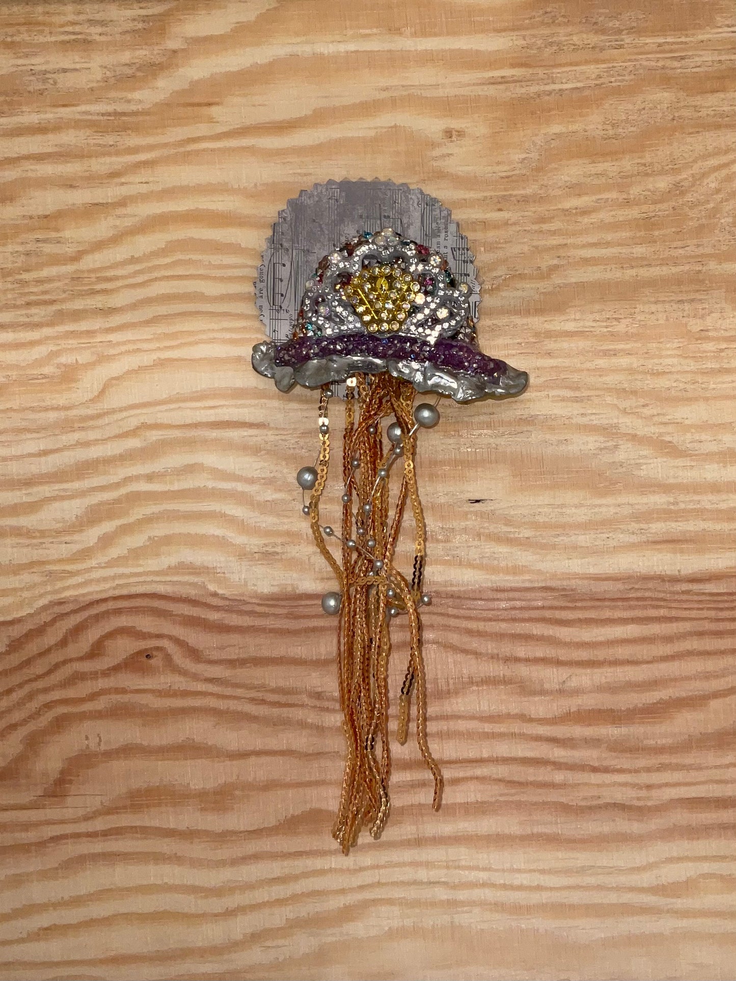 Decorative brooch with beads on a wooden surface