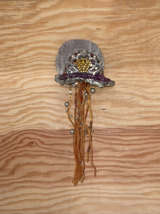 Decorative brooch with beads on a wooden surface