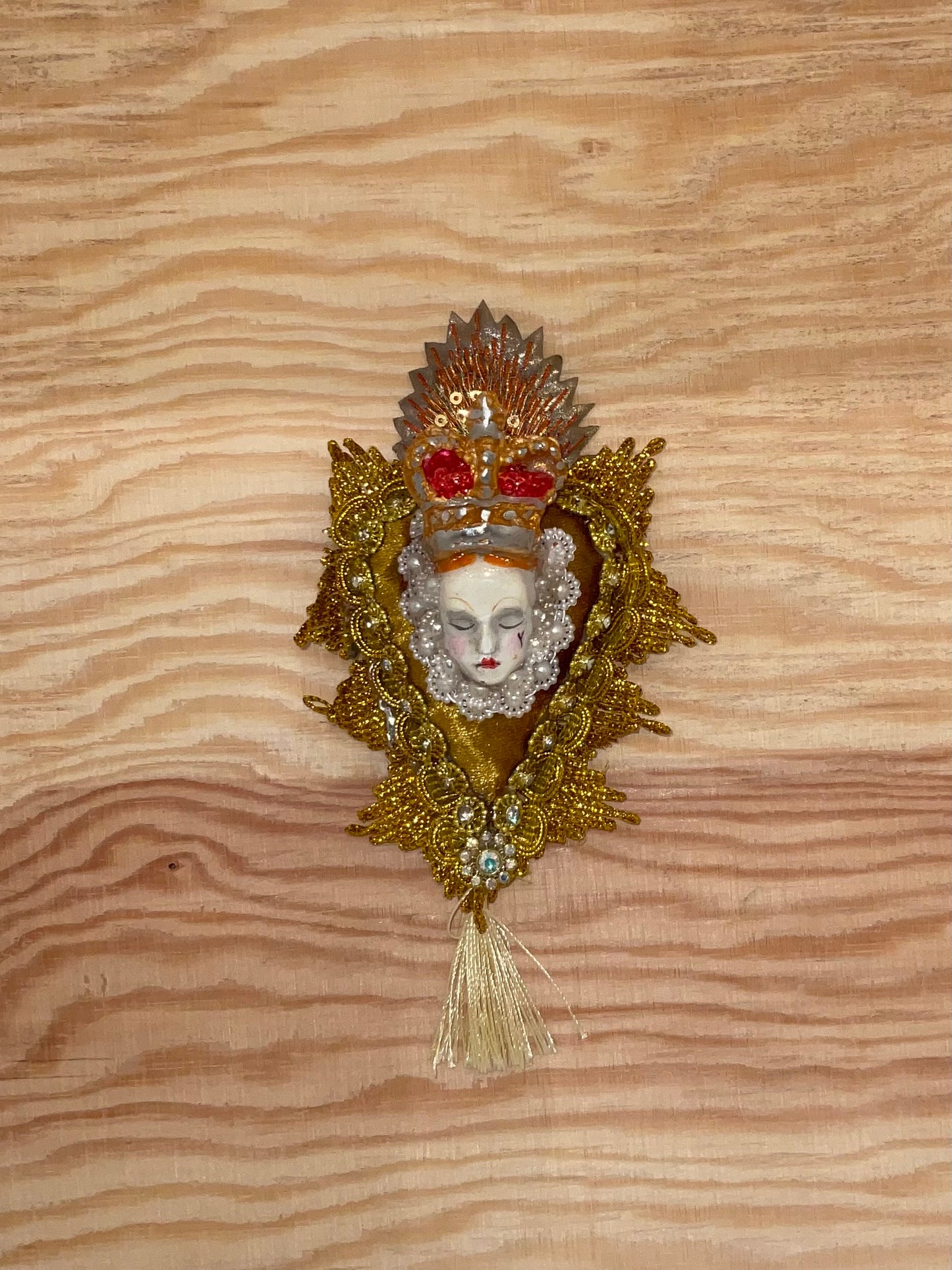 Decorative brooch with a face design on a wooden surface