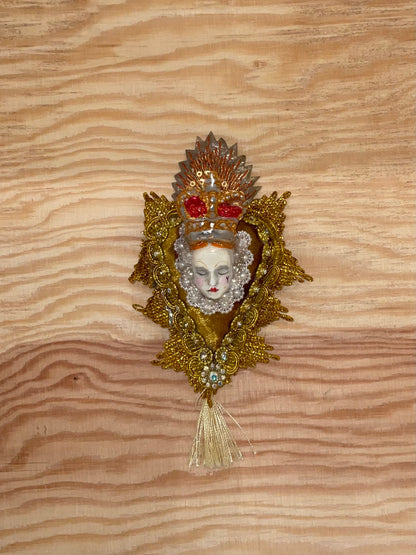 Decorative brooch with a face design on a wooden surface
