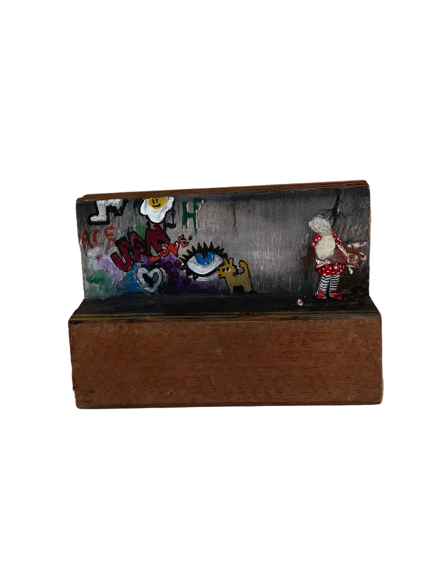Decorative clutch with embroidered designs on a wooden stand against a wooden background