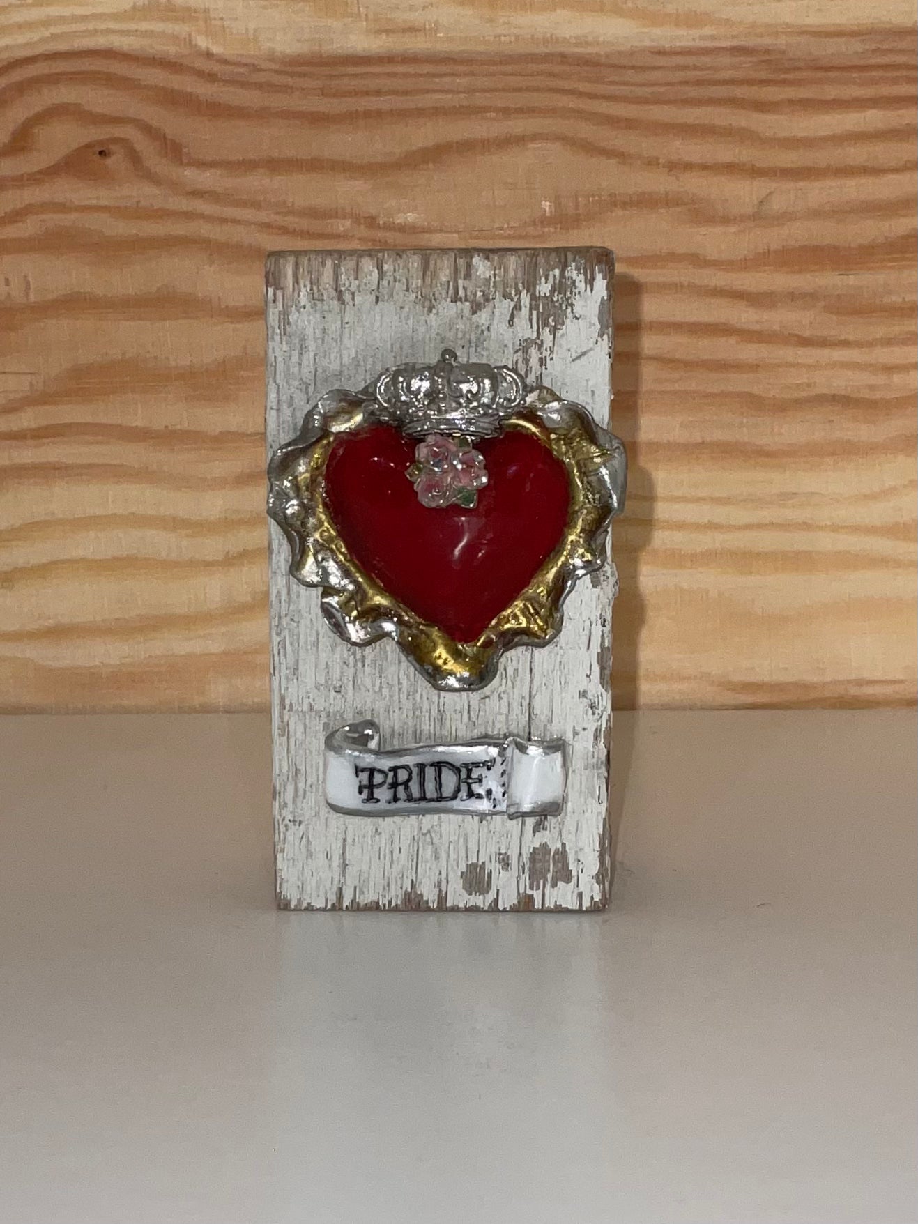 Decorative heart with 'Pride' text on a wooden block