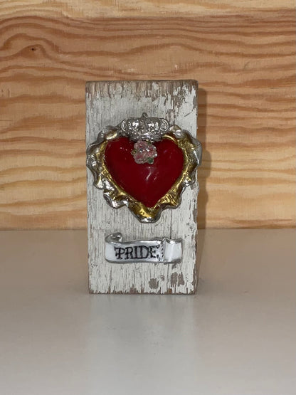 Decorative heart with 'Pride' text on a wooden block