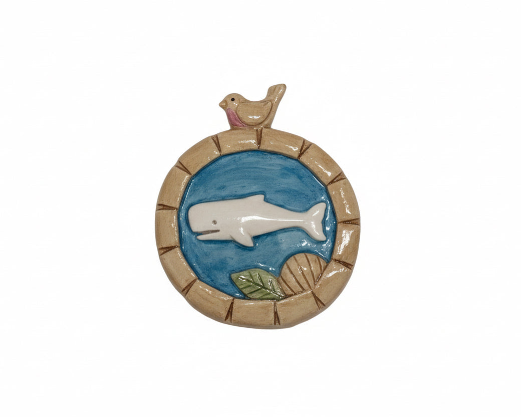 Decorative wall piece with a whale and bird design on a white background