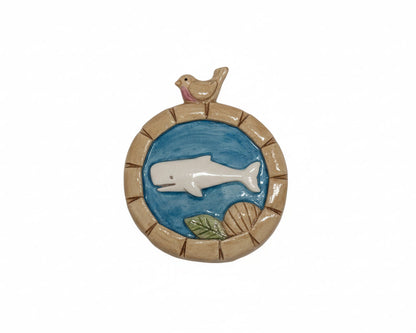 Decorative wall piece with a whale and bird design on a white background