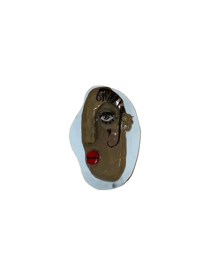 Metallic face object on a wooden surface