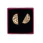 A pair of textured gold crescent-shaped earrings displayed inside a square magenta jewelry box with a black velvet lining, set against a plain white background.