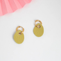 A pair of gold hoop earrings with textured olive green oval drop charms, displayed on a clean white surface with a pink paper fan in the top-left corner.