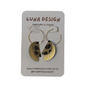 A pair of gold-tone hoop earrings with crescent moon and leopard-print dangle charms, displayed on a grey LUNA DESIGN brand card.