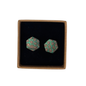 A pair of hexagonal stud earrings with a green and brown leopard print pattern, presented in a square black velvet box with a brown cardboard border on a white background.