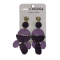 A pair of purple and black layered geometric dangle earrings with gold-tone studs, displayed on a white card labeled 'LUNA DESIGN'.