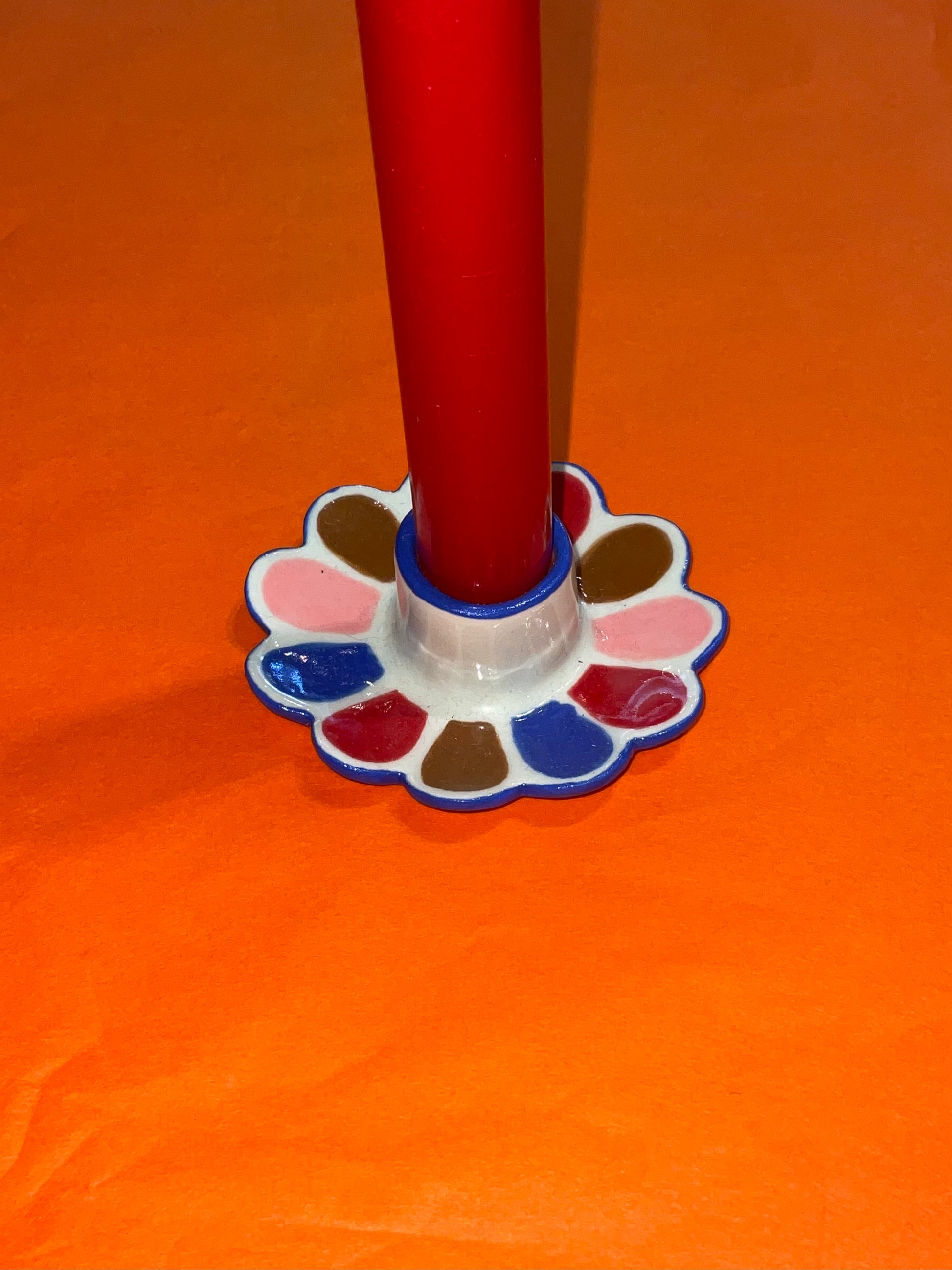 Red pen with a white cap on an orange background