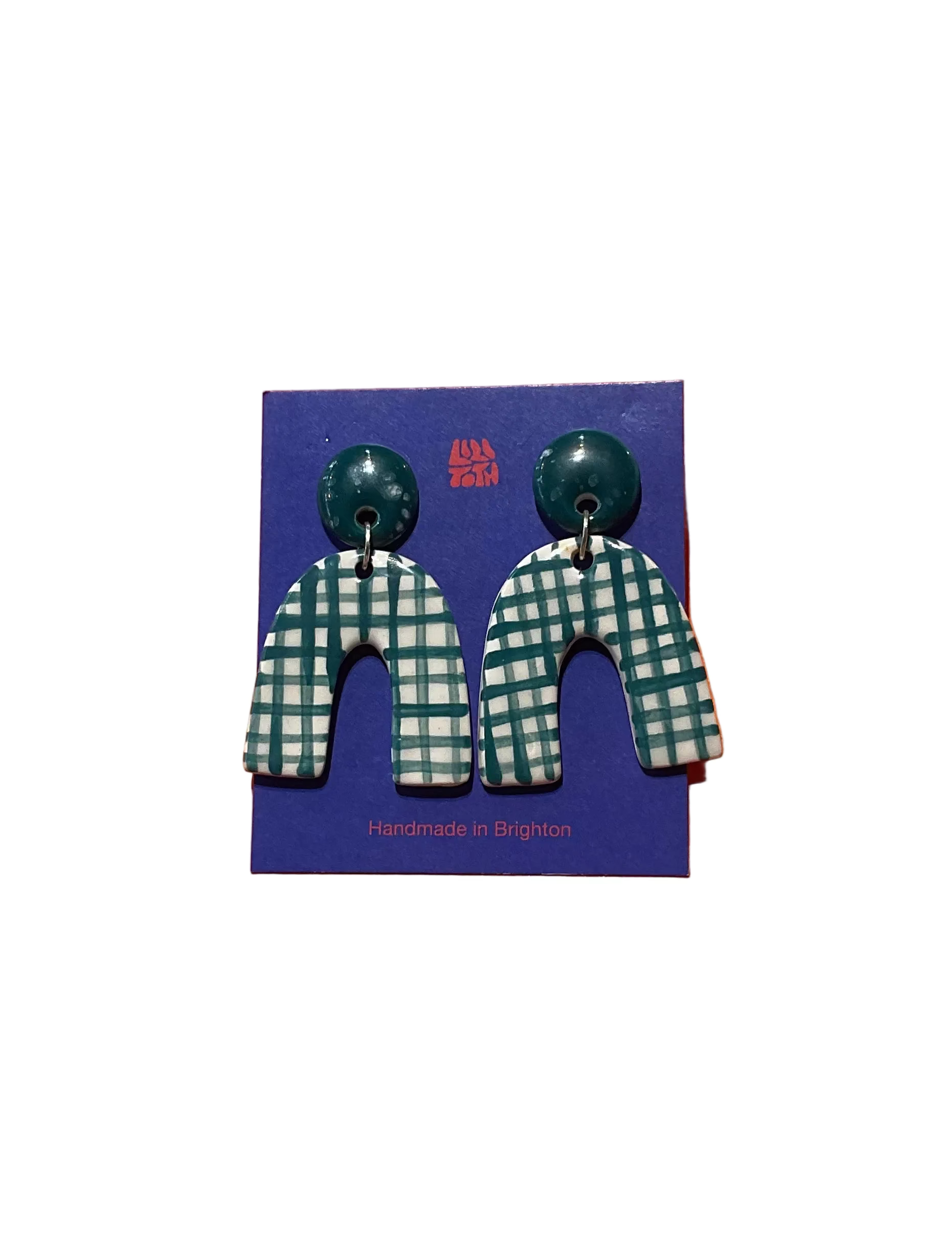 Green and white checkered earrings on a blue card with 'Handmade in Brighton' text, against an orange background.