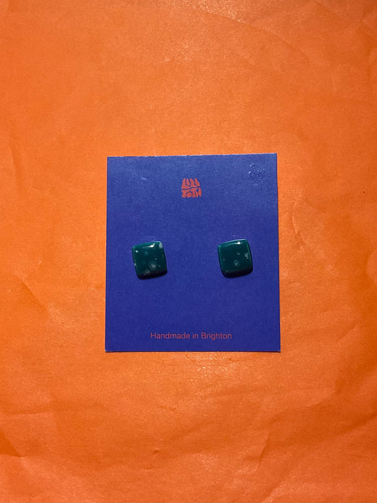 Green square earrings on a blue card with 'Handmade in Brighton' text, against an orange background.