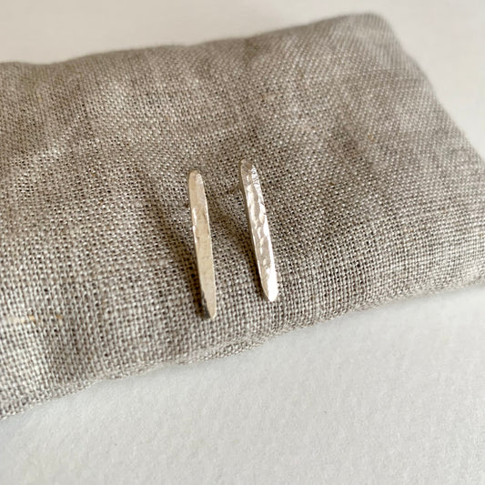 Silver hoop earrings on a textured gray surface
