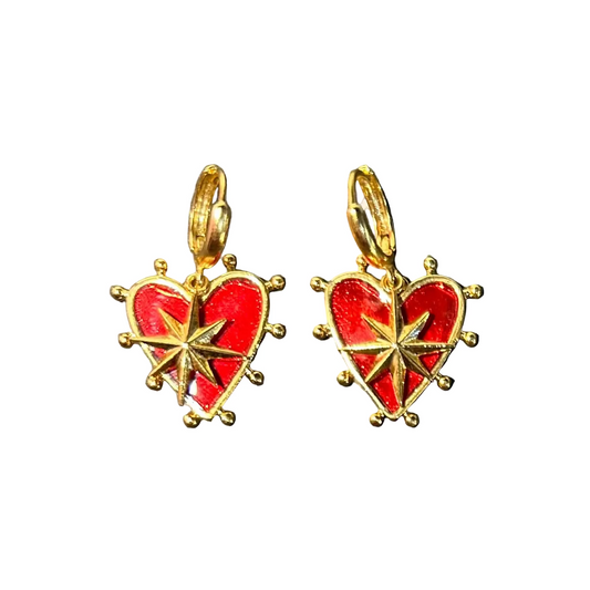 Heart-shaped earrings with red center and gold border on a dark gray background