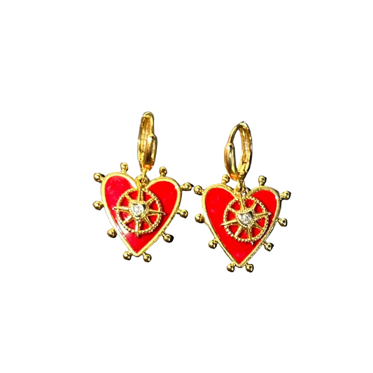 Heart-shaped earrings with gold accents and red enamel on a dark surface
