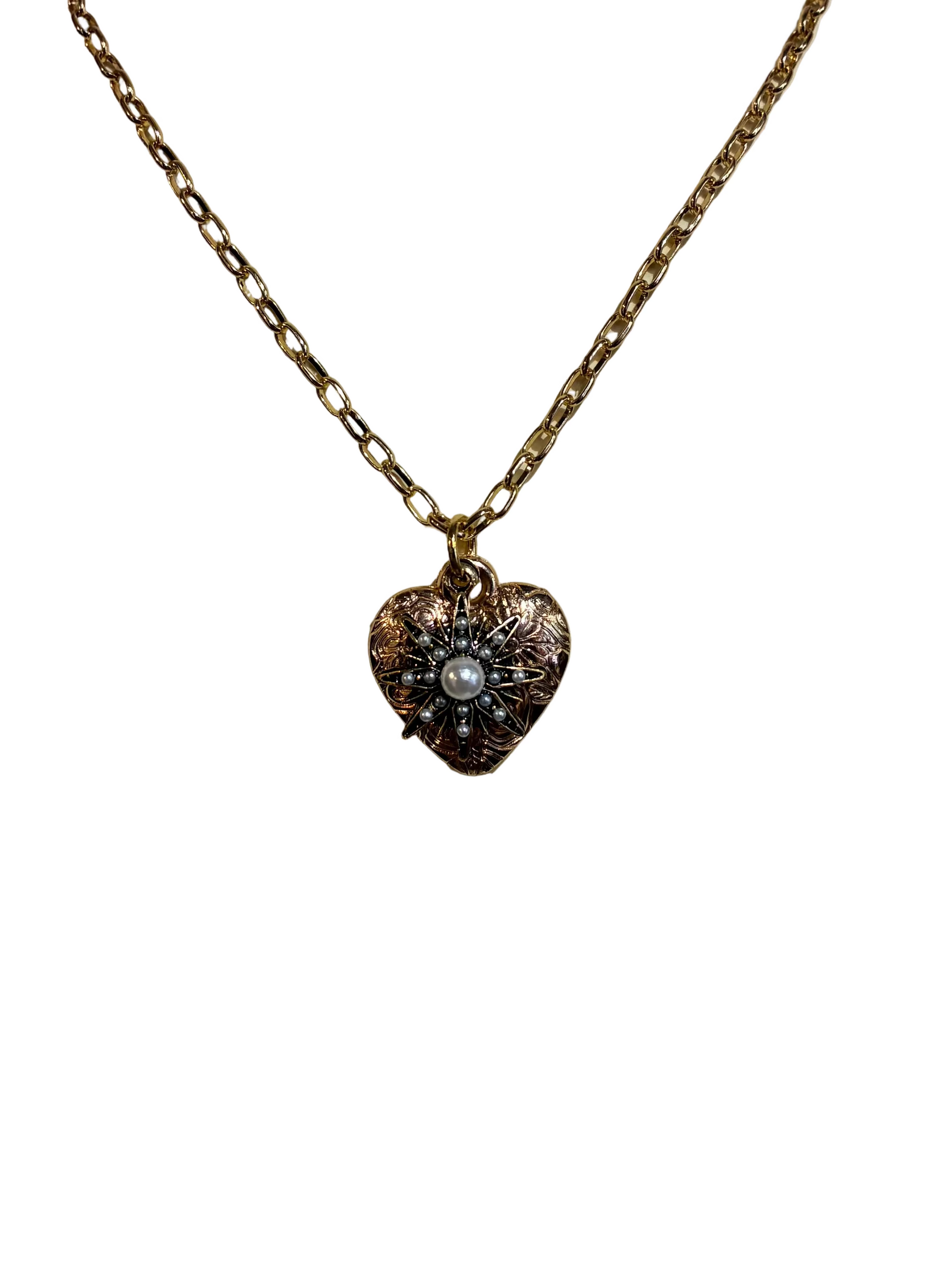 Heart-shaped pendant necklace with a pearl on a beige stone surface
