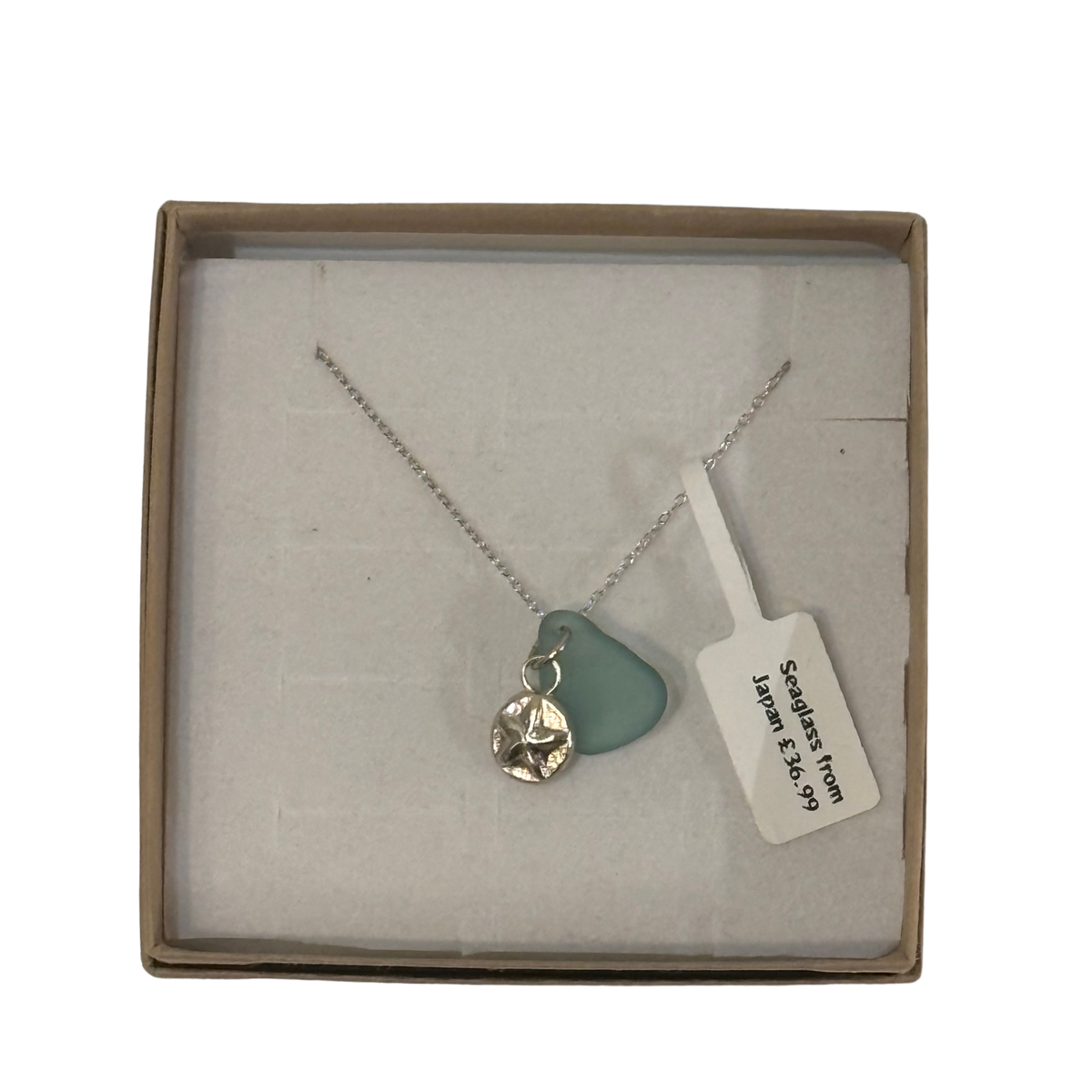 A frosted piece of green glass with collected from Japan, paired with a sterling silver starfish hung on a sterling silver 18 inch belcher chain.