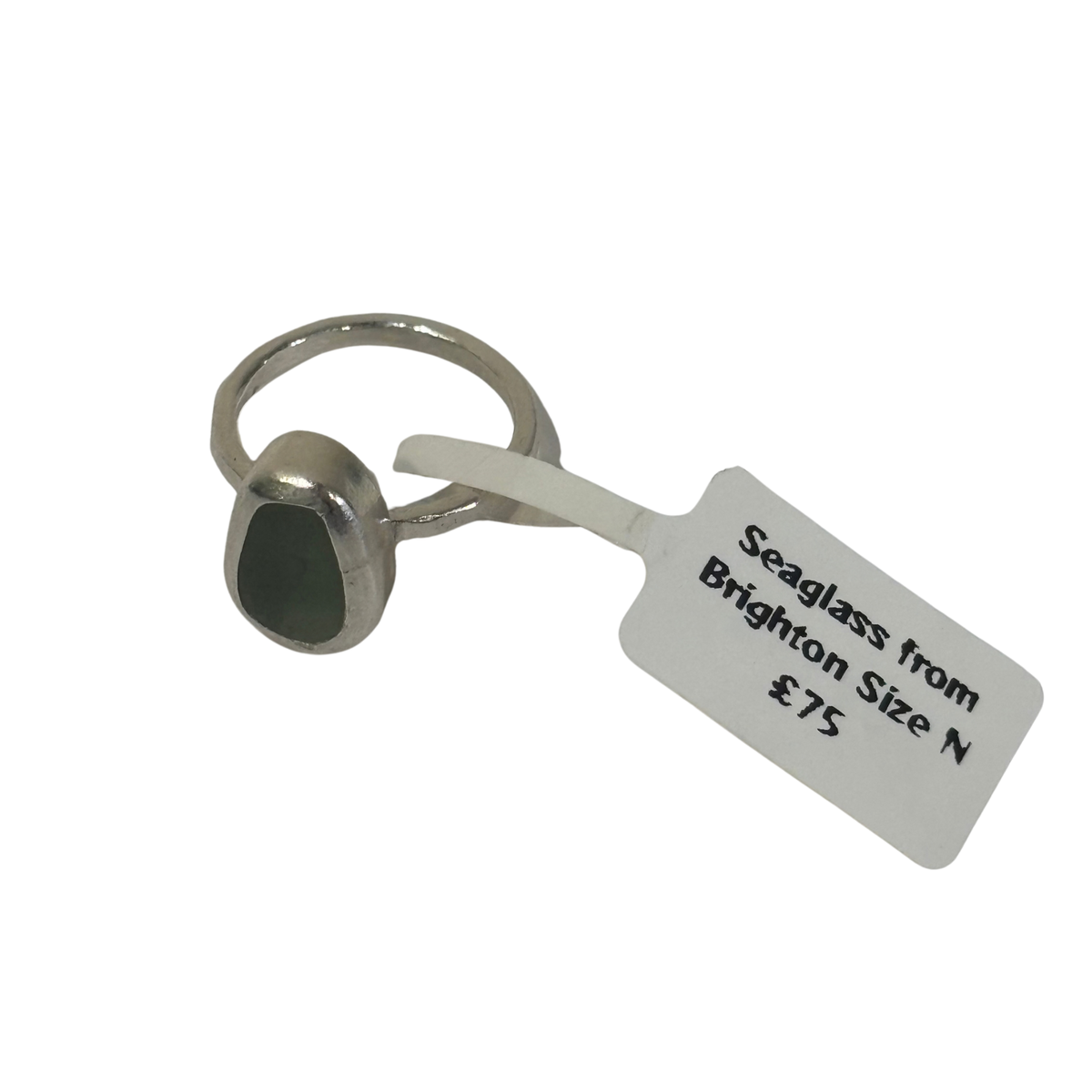 A silver-toned ring with a dark green seaglass stone, shown with a white paper tag that reads 'Seaglass from Brighton Size N £75' on a plain white background.