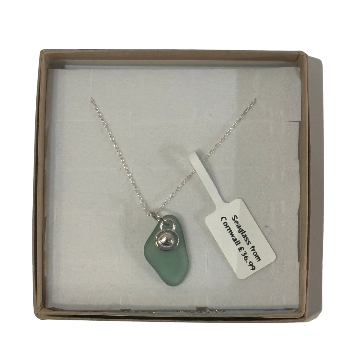 A frosted piece of green glass with collected from Cornwall, paired with a sterling silver shell hung on a sterling silver 18 inch belcher chain.