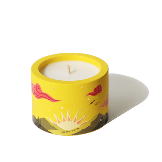 Candle in a yellow container with cartoon designs on a white background